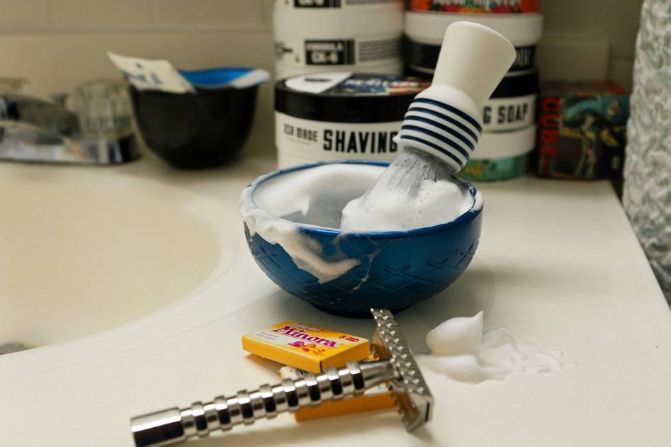 A collection of artisanal shaving soaps with natural ingredients on a rustic background