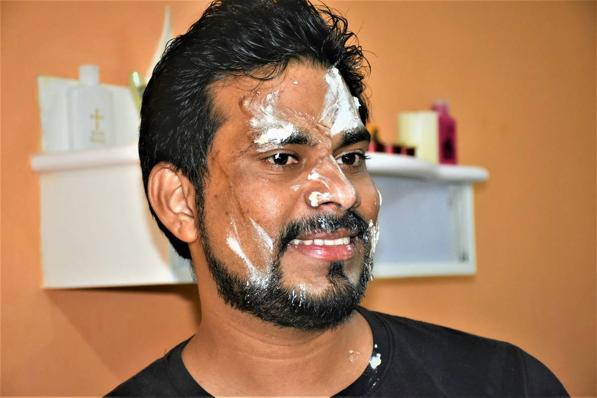 Man using grooming supplies beard exfoliating balm before applying shaving soap